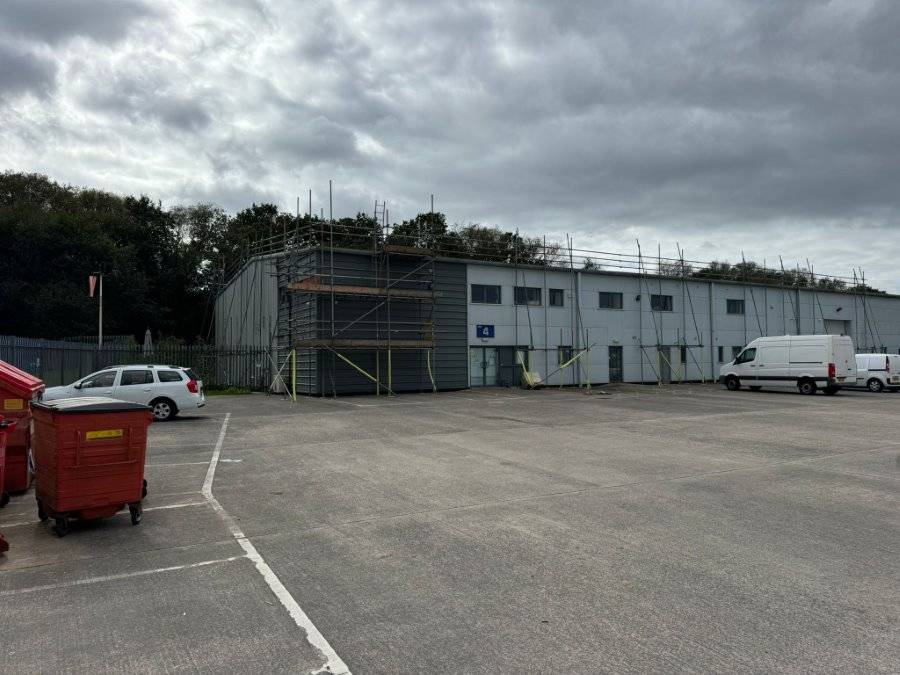 a building with scaffolding and cars parked in front of it
