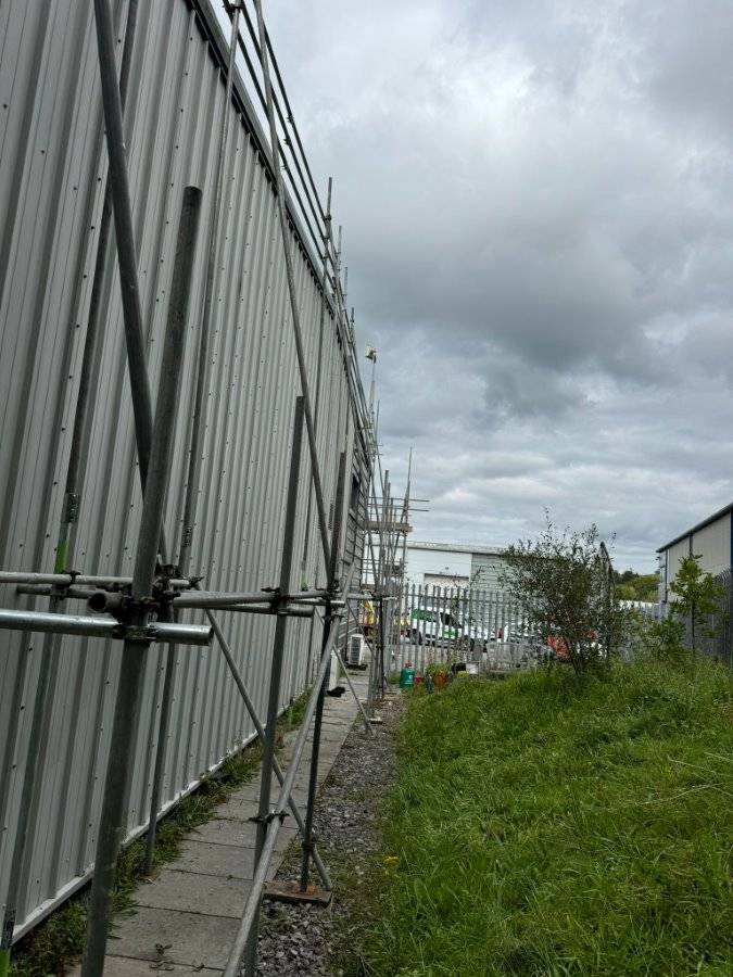 a building with scaffolding next to a fence